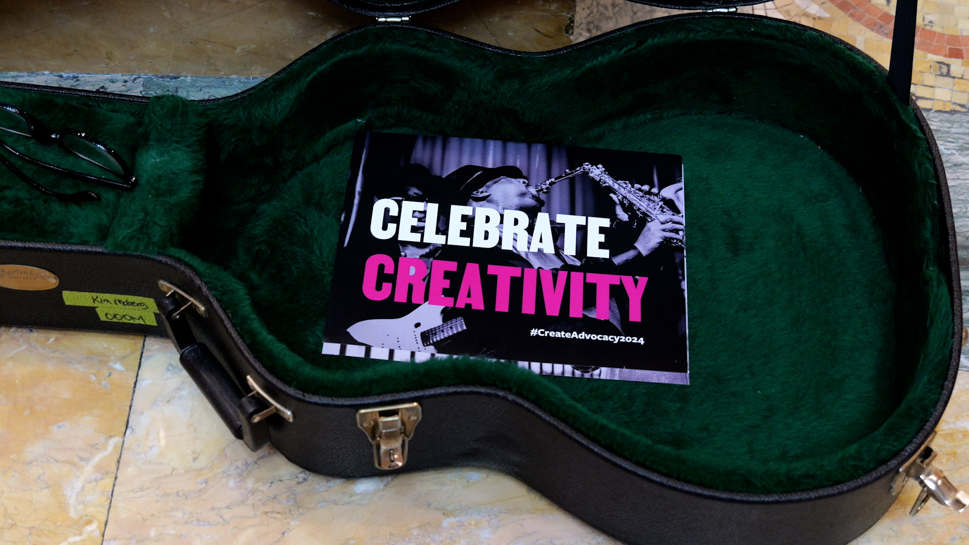 Photo of a sign that says "Celebrate Creativity" in a guitar case.