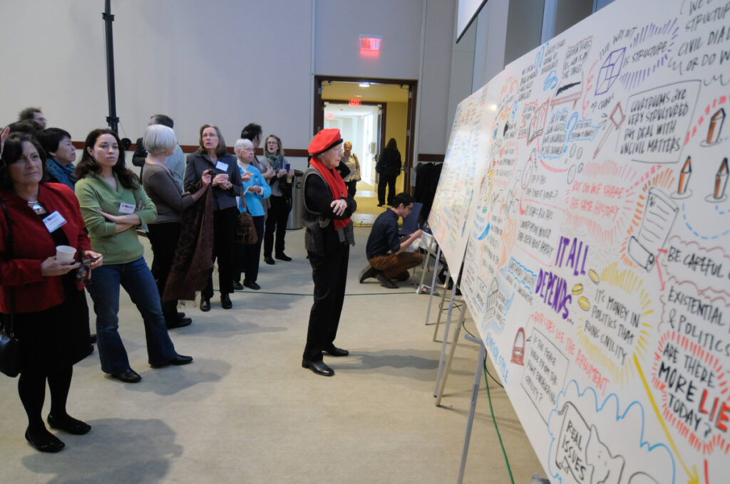 People look at a display board at a forum event.