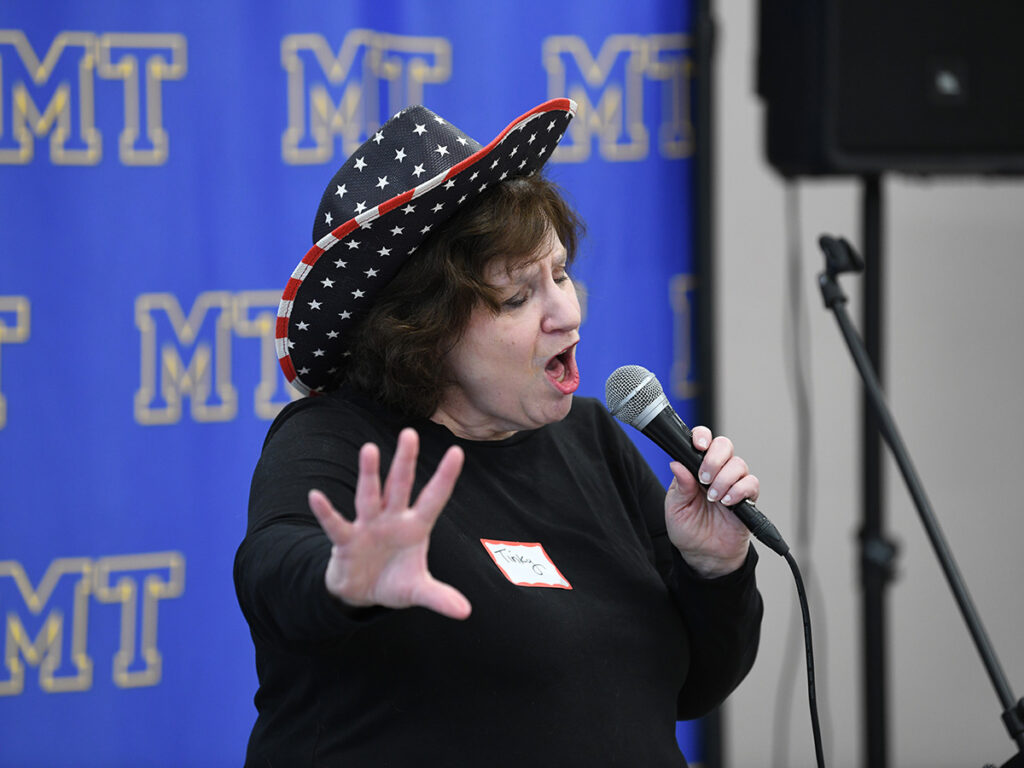 Photo of a Tinky Weisblat singing at the Museum on Main Street "Voices and Votes" opening night at Mohawk Trail Regional School.