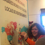 Photo of a woman placing a pin on a map.
