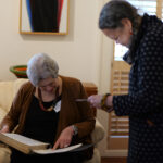 Two Mass Humanities board members look at Mass Humanities archival documents.