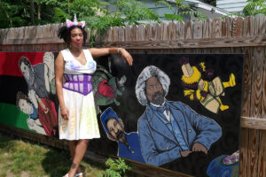 Photo of artist Digi Chivetta and her portrait of Douglass.