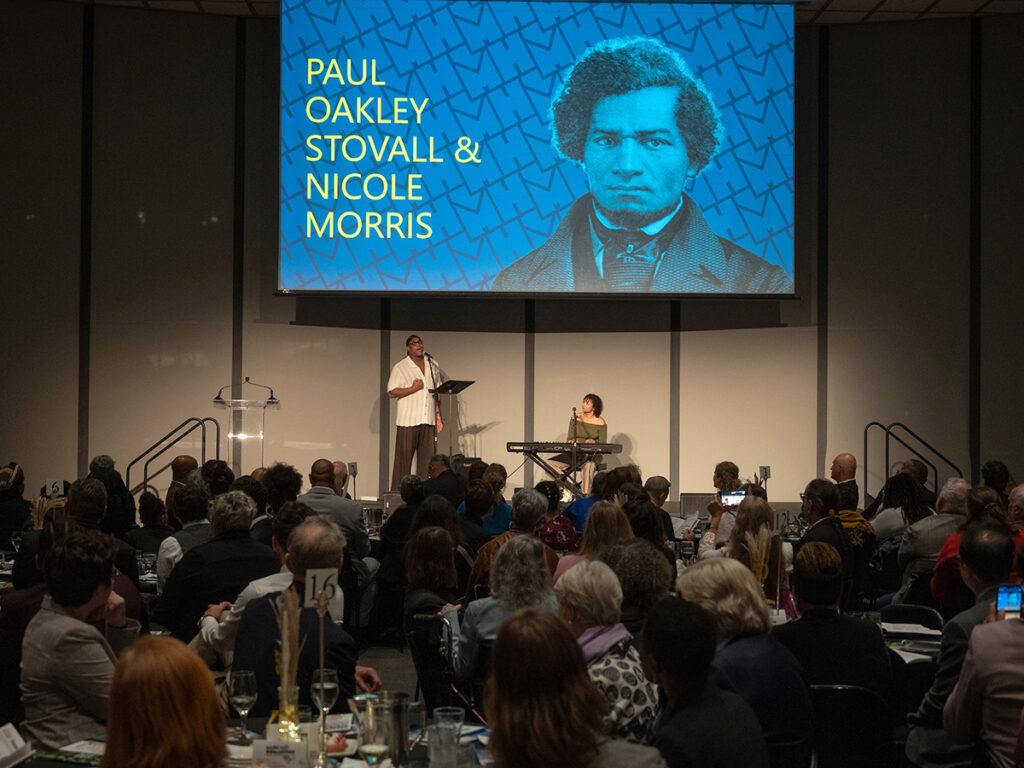 Paul Oakley Stovall and Nicole Morris perform on stage.